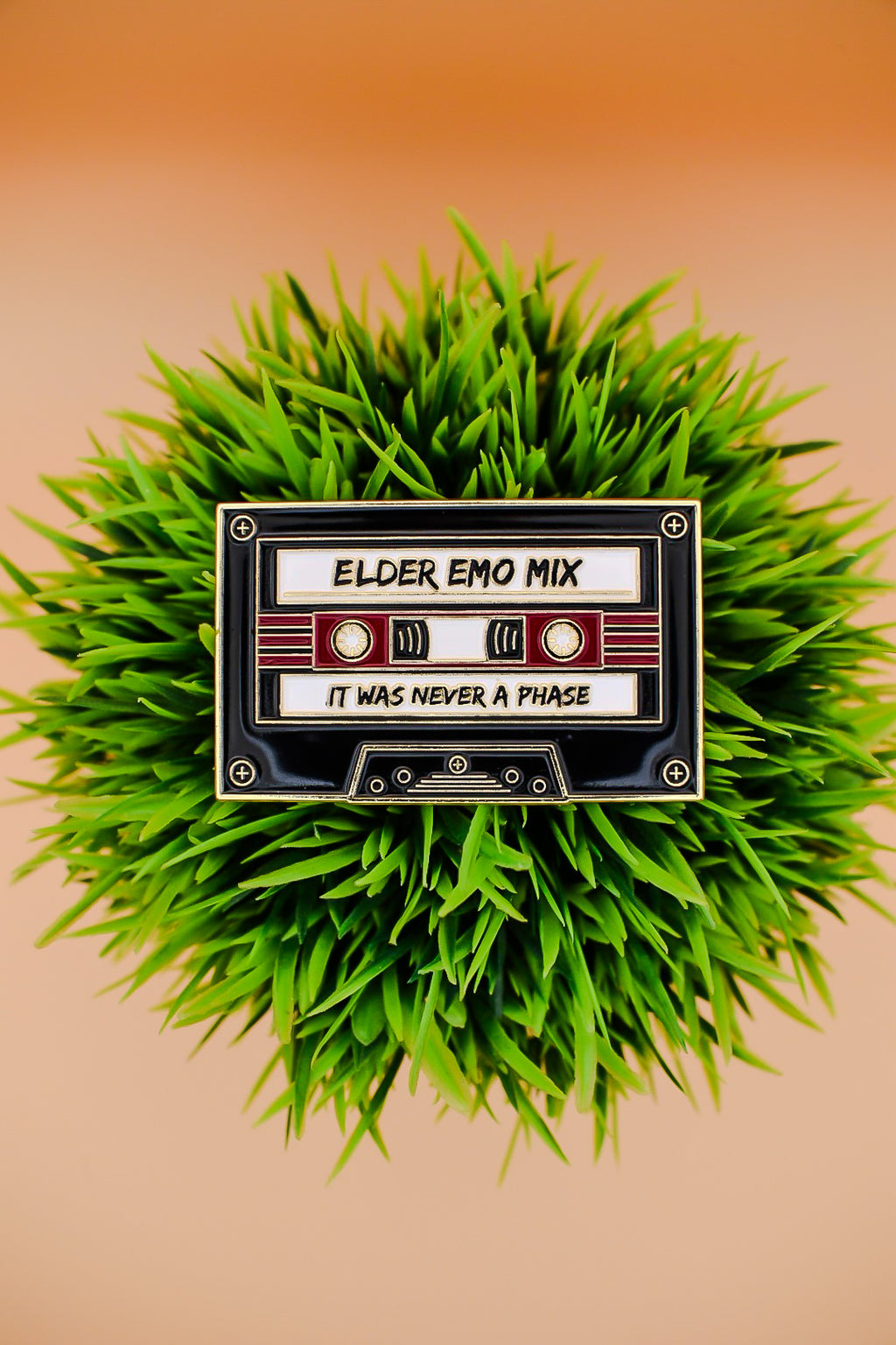 Tape cassette labeled 'Elder Emo Mix' on a grassy background