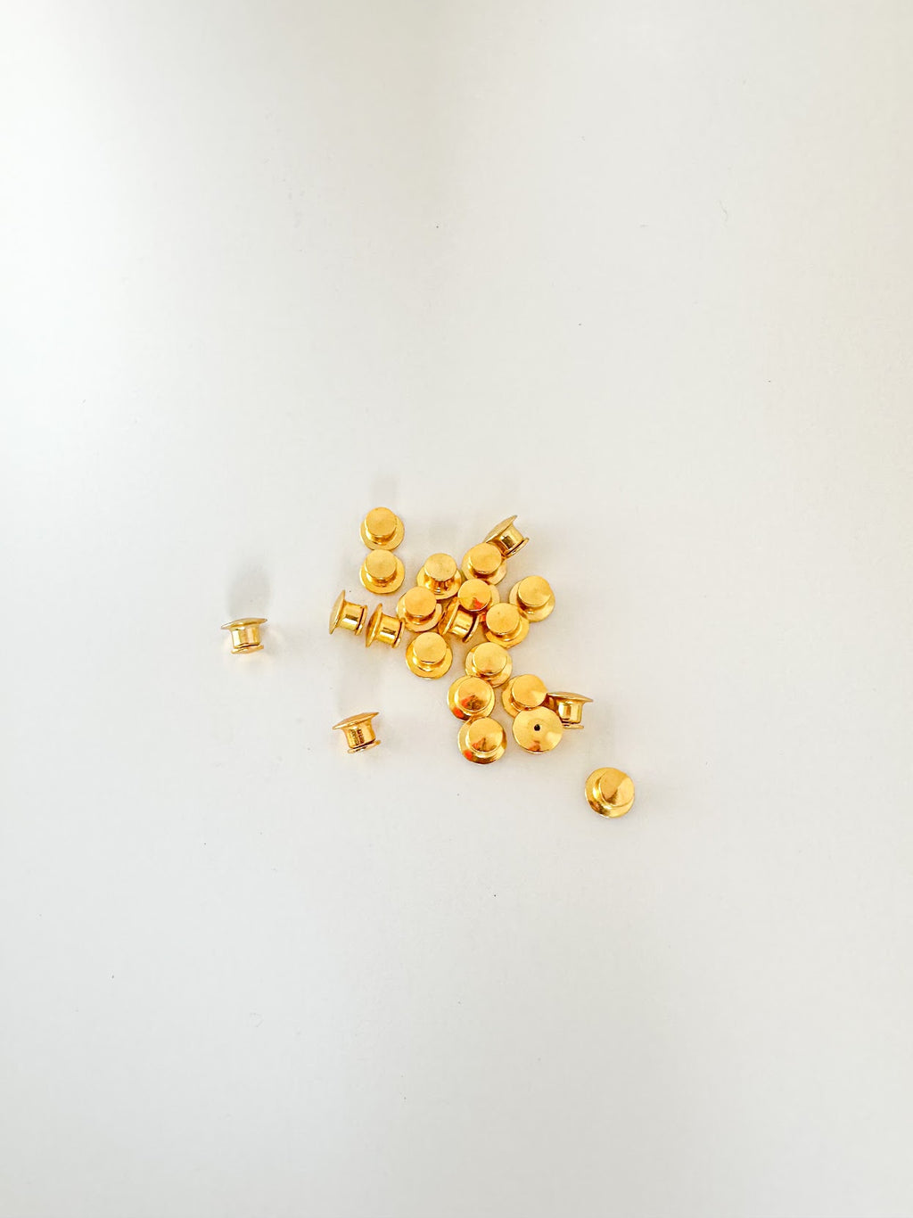 A handful of gold locking pin backs