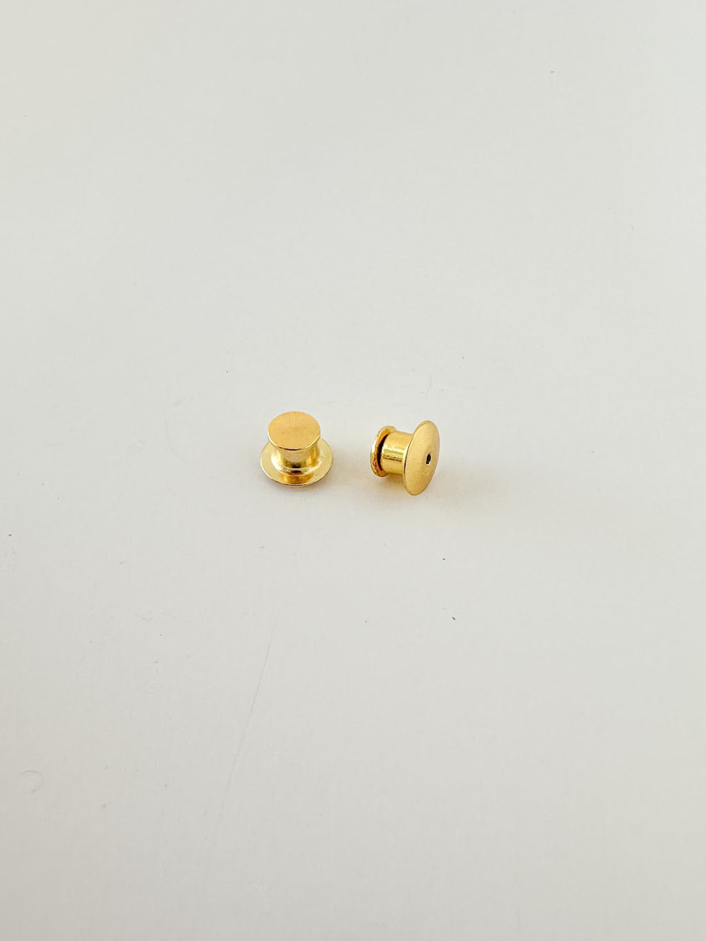A pair of gold locking pin backs