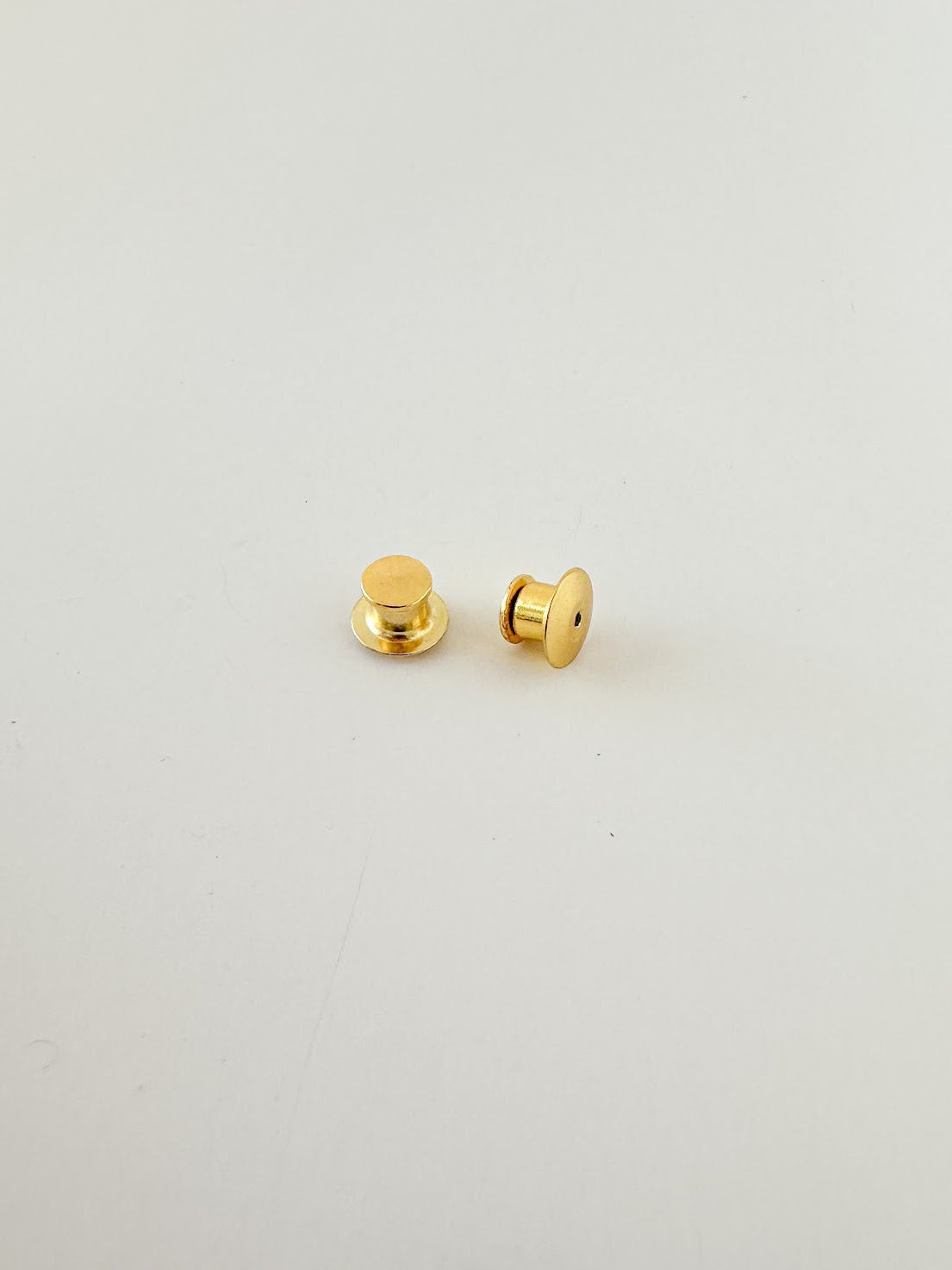 A pair of gold locking pin backs
