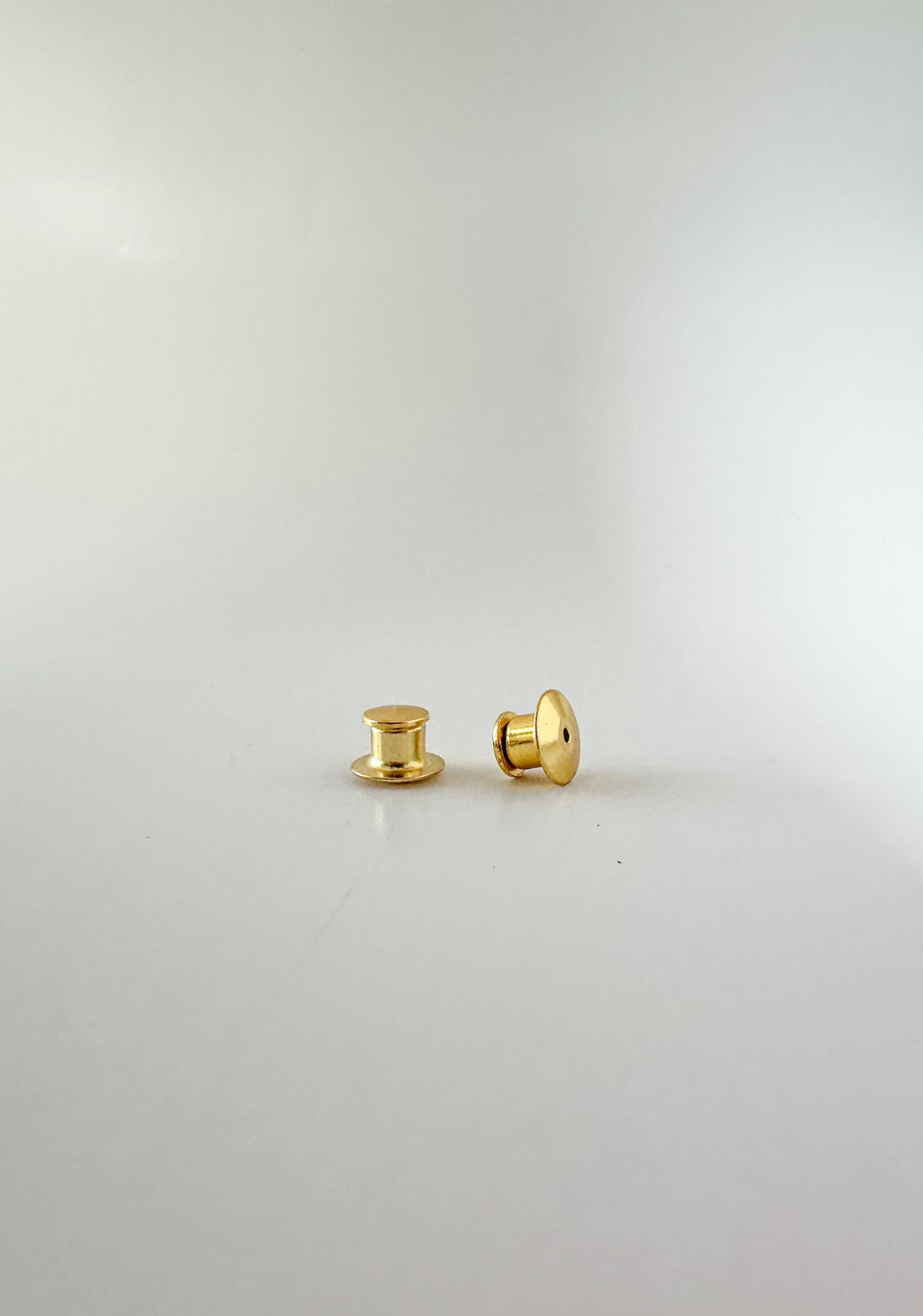 A pair of gold locking pin backs