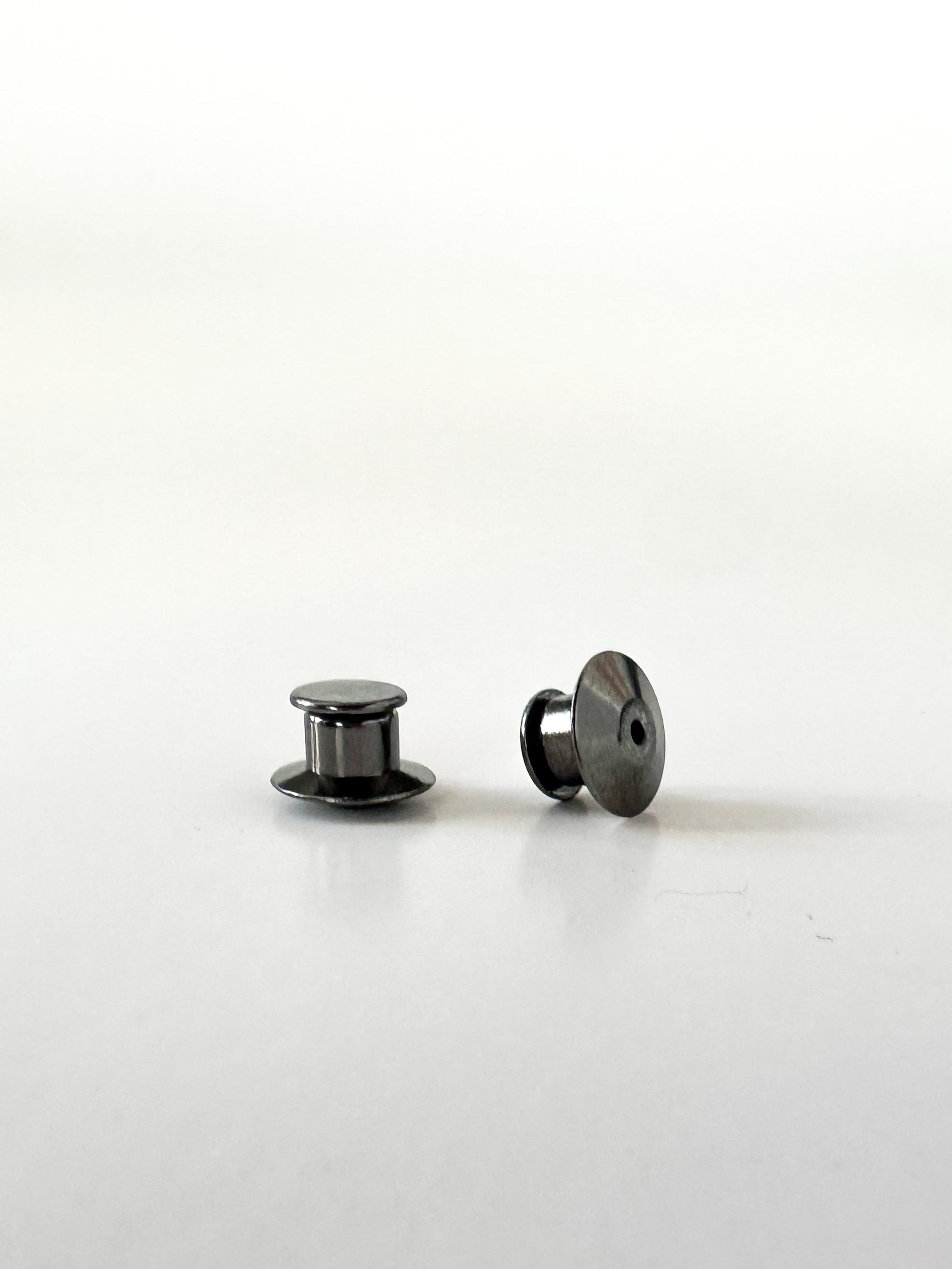 Two black locking pin backs