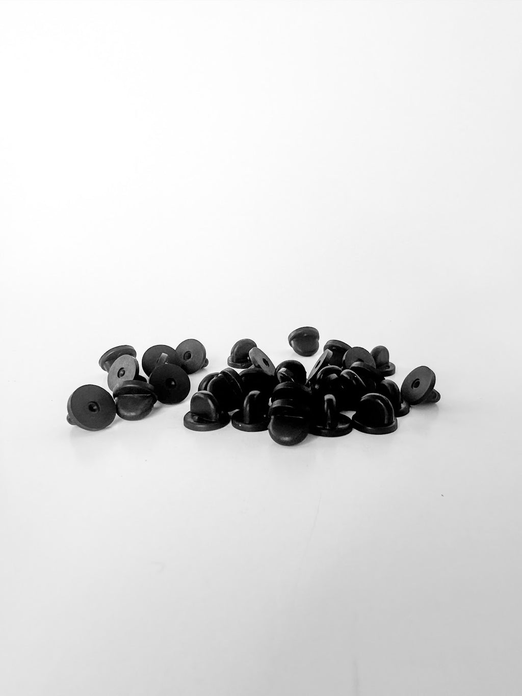 A group of black PVC rubber pin backs
