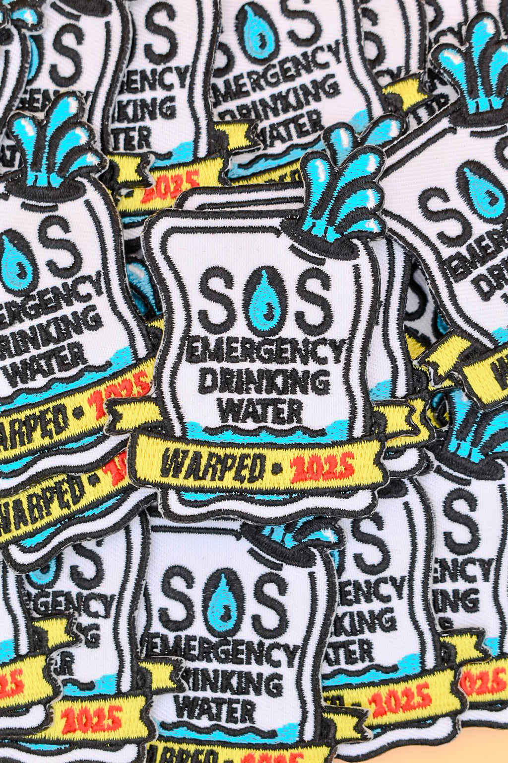 Multiple patches of SOS Emergency Drinking Water with 'Warped 2025' text.