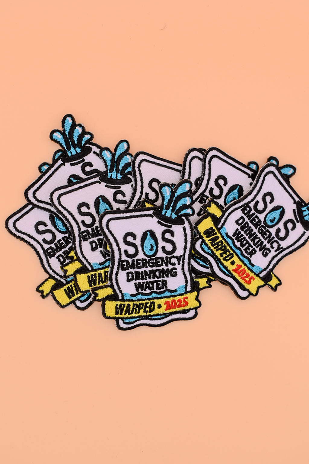 Collection of SOS Emergency Drinking Water patches on a peach background
