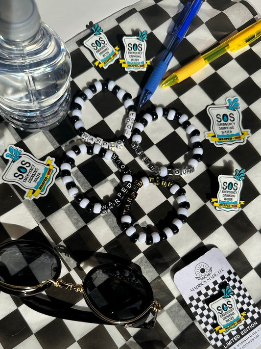 Black and white bracelets with Warped Tour letters on a checkered surface with decorations for embellishment