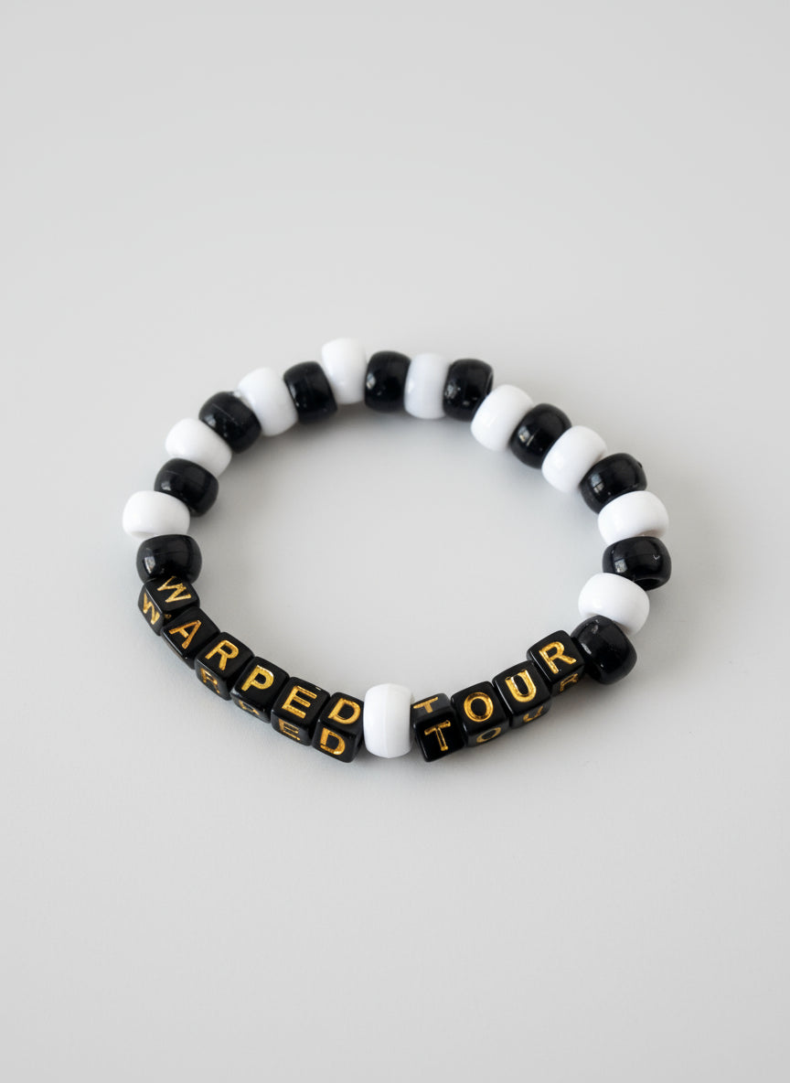 Black and white beaded bracelet with 'Warped Tour' text on a white background