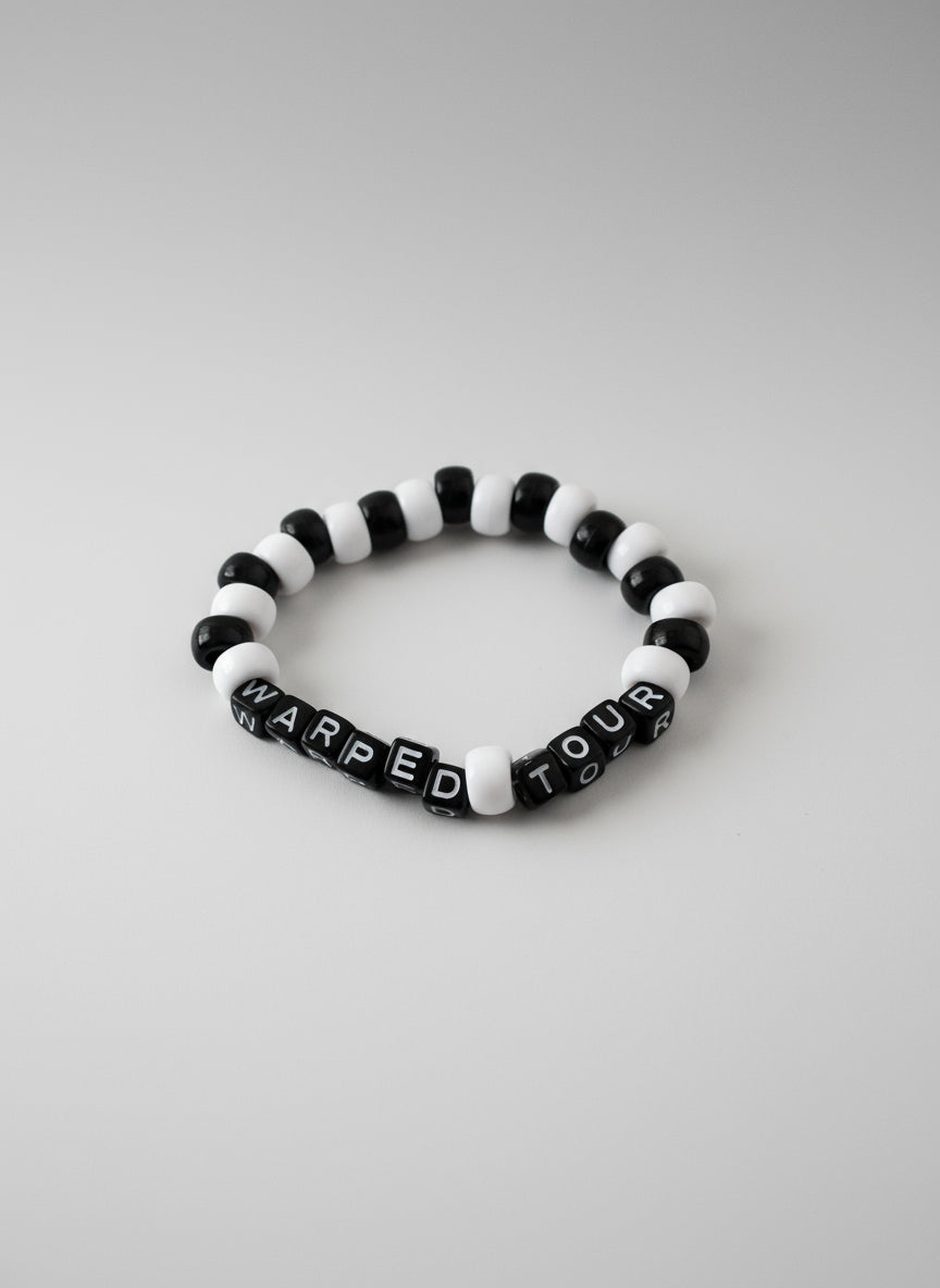 Black and white beaded bracelet with 'Warped Tour' text on a white background