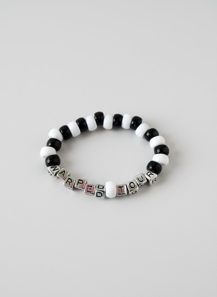 Black and white beaded bracelet with "Warped Tour" text on a white background